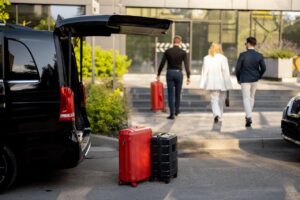 Driver helps a business couple carry their suitcases to the hotel