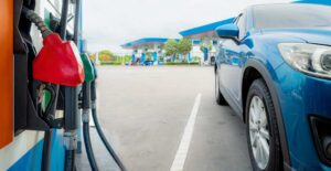 Blue luxury SUV car fueling at gas station. Refuel fill up with petrol gasoline. Petrol pump filling