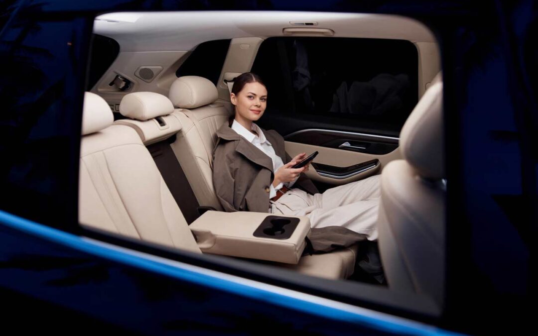 woman sits in the back seat of a limousine